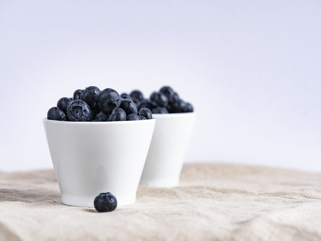 Image of blueberries in short white bowls.